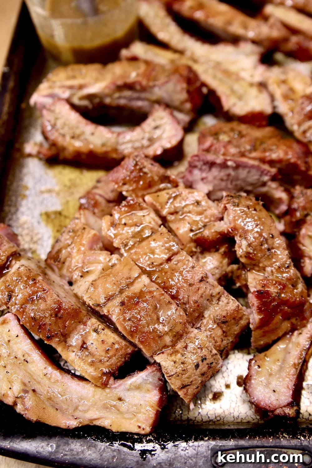 Orange Pineapple Marinated Ribs sliced on a sheet pan
