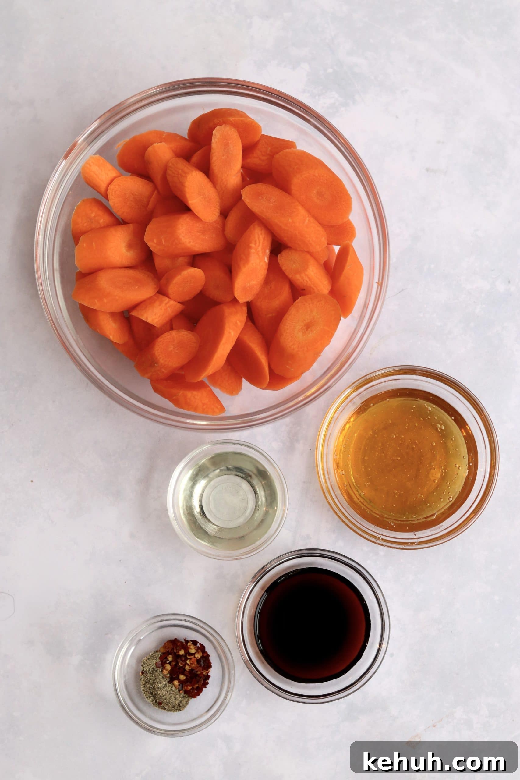 Carrots, honey, soy sauce, oil, and red pepper flakes in prep bowls