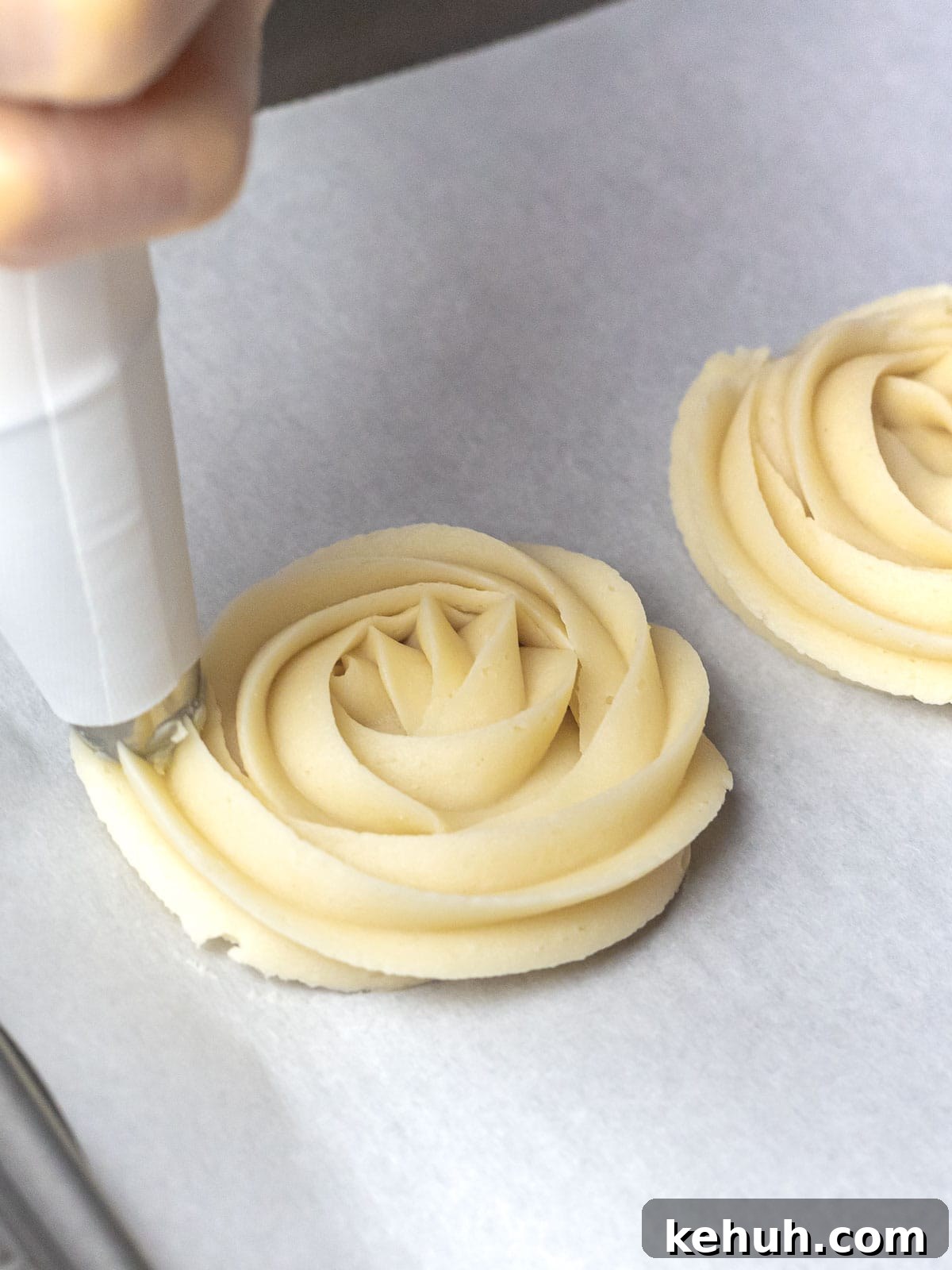 Classic Butter Cookies: Simple 6-Ingredient Recipe 4 butter cookie dough being piped into rosettes with a piping bag