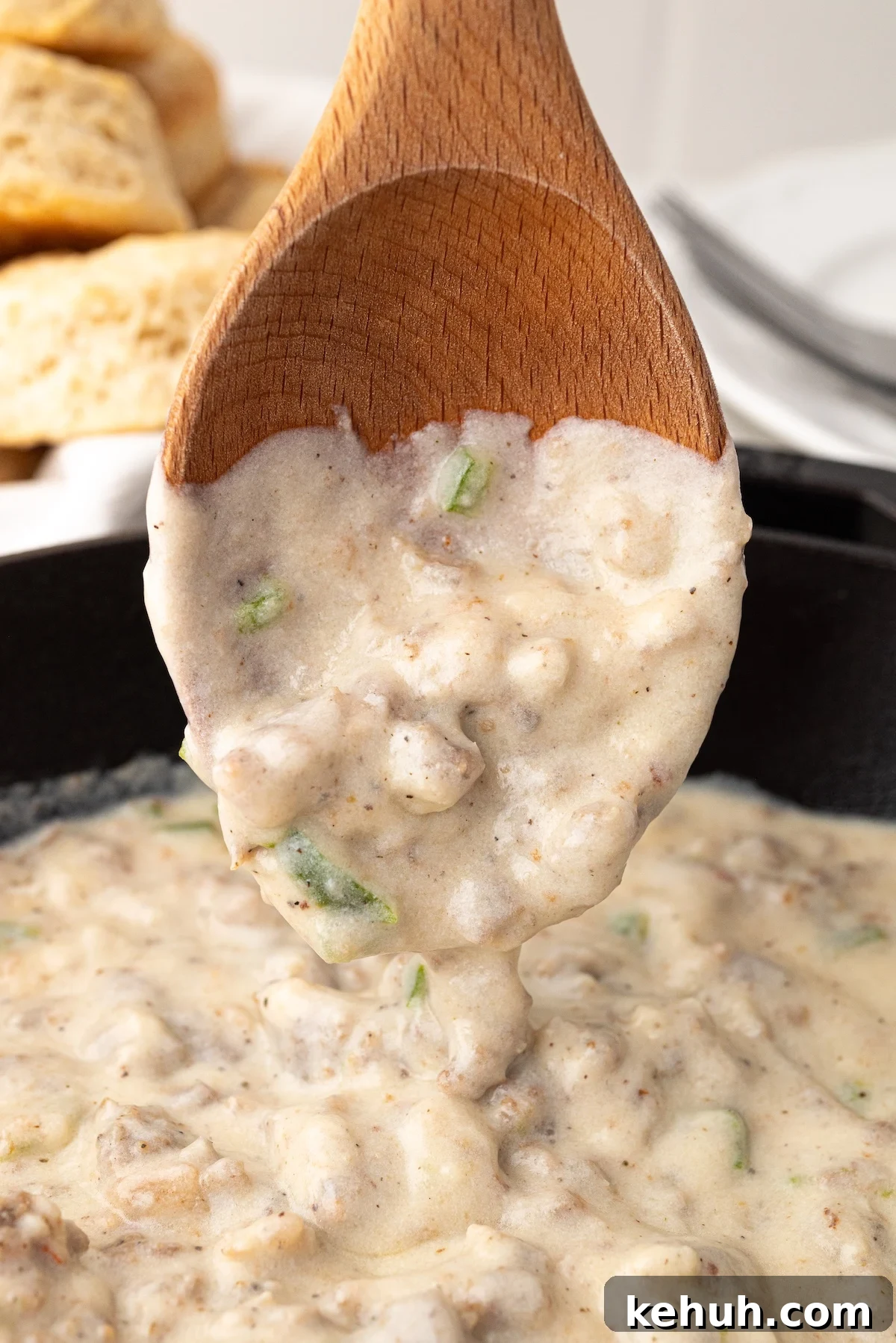 wooden spoon with creamy jalapeno sausage gravy