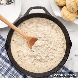 cast iron skillet of jalapeno sausage gravy next to fresh biscuits