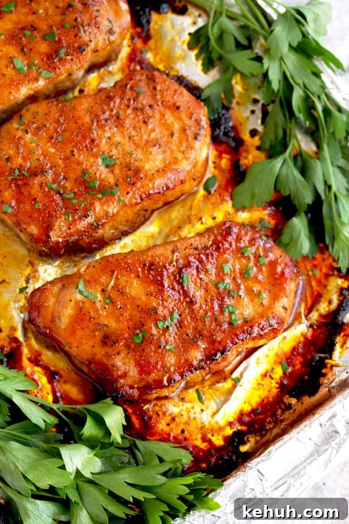 Baked pork chops on a sheet pan.