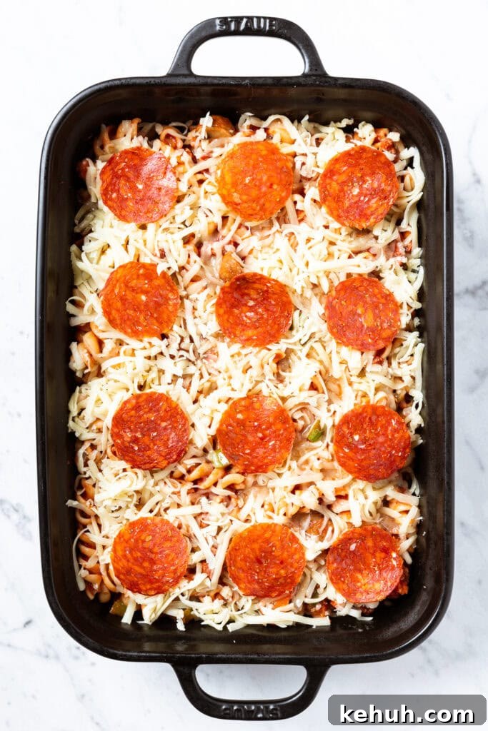 Cheesy Pizza Casserole Recipe with Sausage and Peppers 13 An unbaked pasta dish.