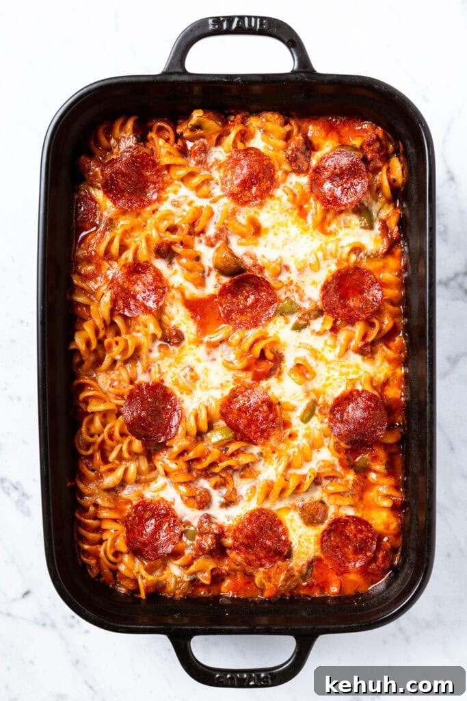Cheesy Pizza Casserole Recipe with Sausage and Peppers 14 A fully baked pizza casserole in a baking dish.