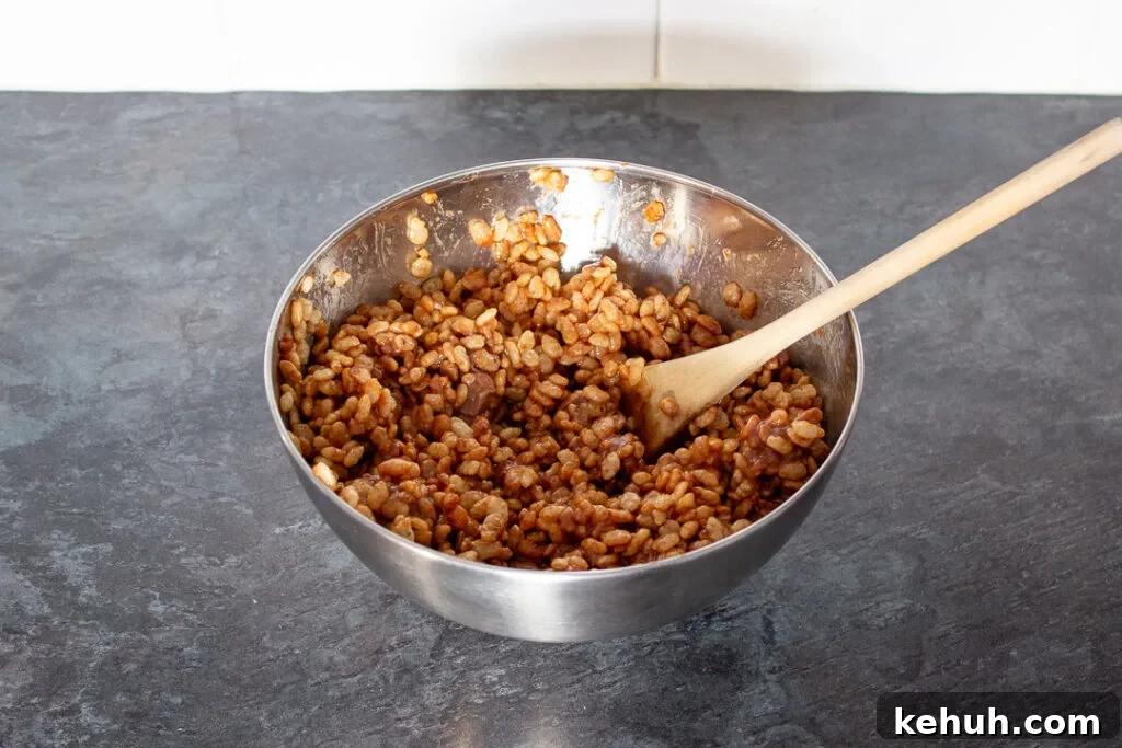 Rice Krispies cereal mixed with melted mars bars in a large mixing bowl.