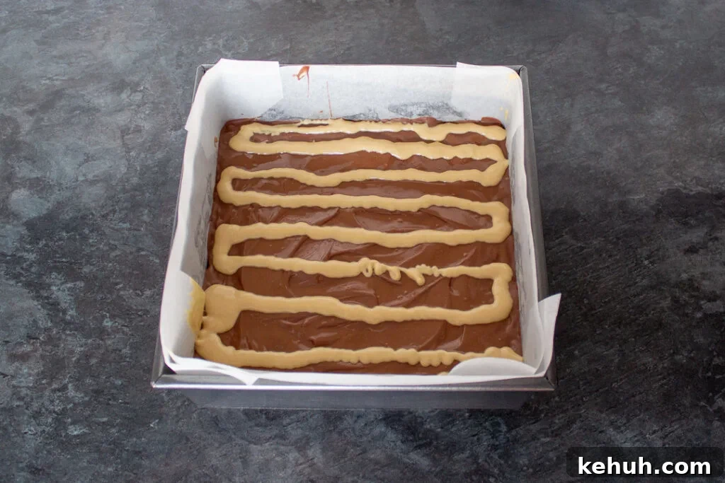 Melted blonde chocolate piped in lines on top of the milk chocolate topping.