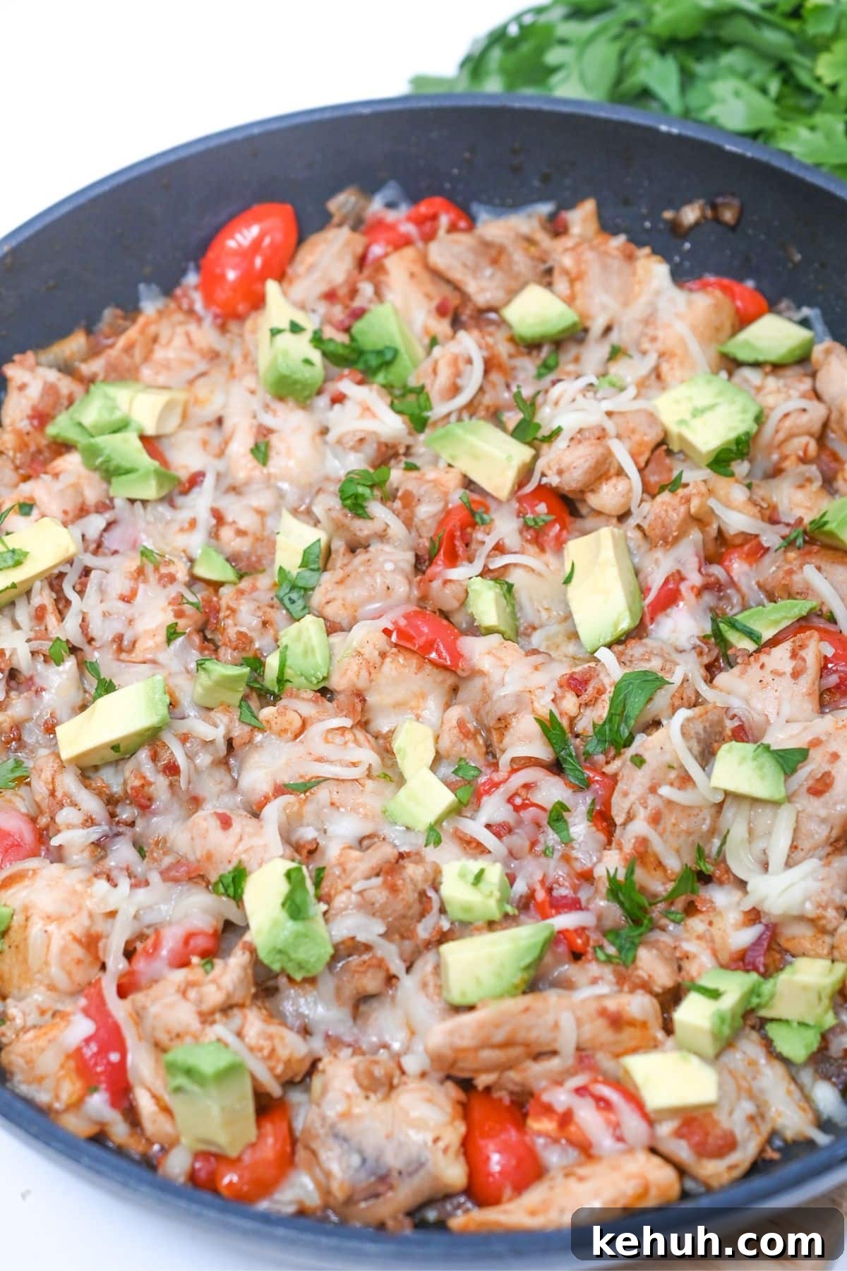 Dairy-Free Chicken Taco Skillet Recipe for Quick Weeknight Meals 2 Cooked chicken skillet, with cheese, pepper, avocado and cilantro on it.