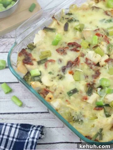 Dairy-free chicken alfredo casserole in a clear casserole dish with green onions on top