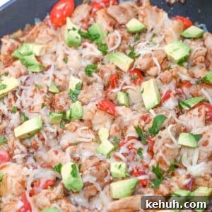 Dairy-Free Chicken Taco Skillet Recipe for Quick Weeknight Meals 14 Cooked chicken skillet, with cheese, pepper, avocado and cilantro on it.