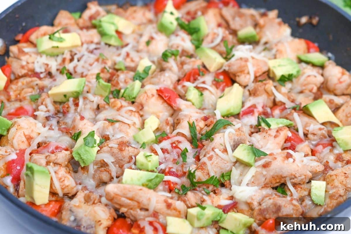 Dairy-Free Chicken Taco Skillet Recipe for Quick Weeknight Meals 15 Cooked chicken skillet, with cheese, pepper, avocado and cilantro on it.