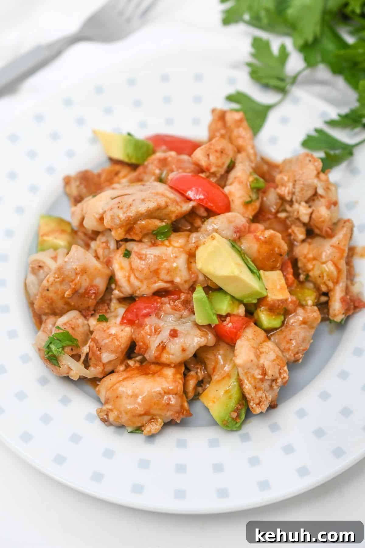 Dairy-Free Chicken Taco Skillet Recipe for Quick Weeknight Meals 9 Chicken, avocado, and pepper on a white plate with cilantro behind it.