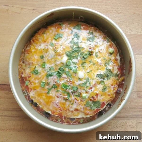Stacked Burrito Pie: Cheesy Mexican Casserole Recipe 3 cooked stacked burrito pie casserole in a round pan