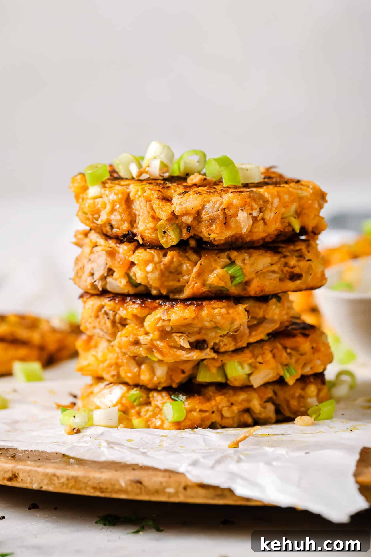 A stack of tuna patties on parchment paper. 