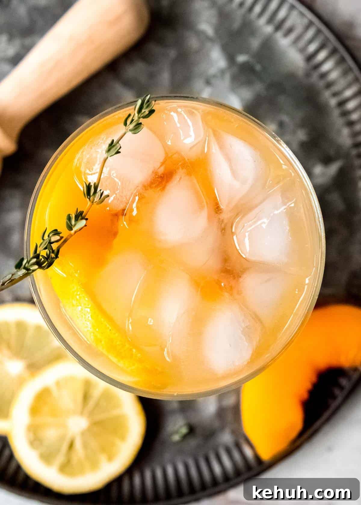 Peach Bourbon Lemonade Recipe — Refreshing Summer Cocktail 12 overhead shot showing a glass of boozy lemonade with peaches and thyme