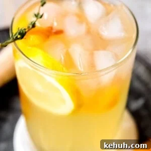 Peach Bourbon Lemonade Recipe — Refreshing Summer Cocktail 13 a tall glass of peach bourbon lemonade with thyme and lemon slices