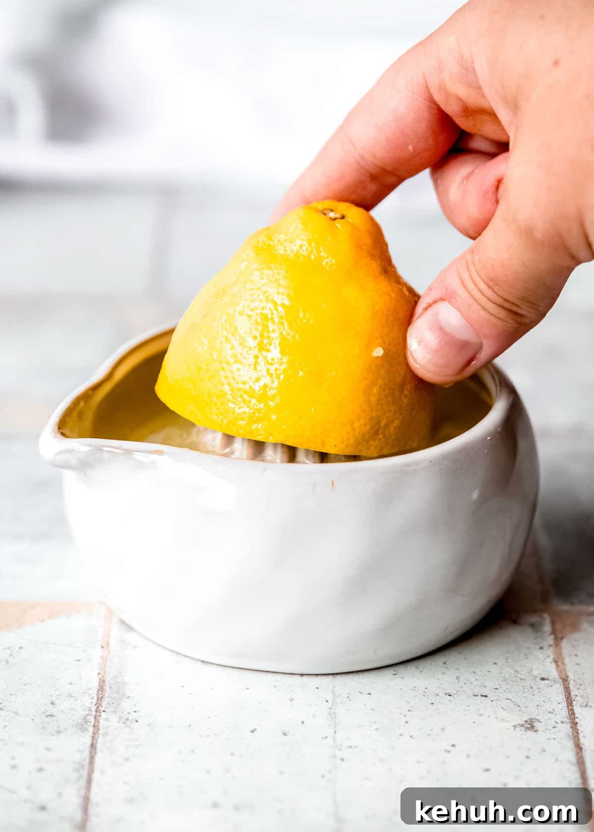 Peach Bourbon Lemonade Recipe — Refreshing Summer Cocktail 4 a hand juicing a lemon half