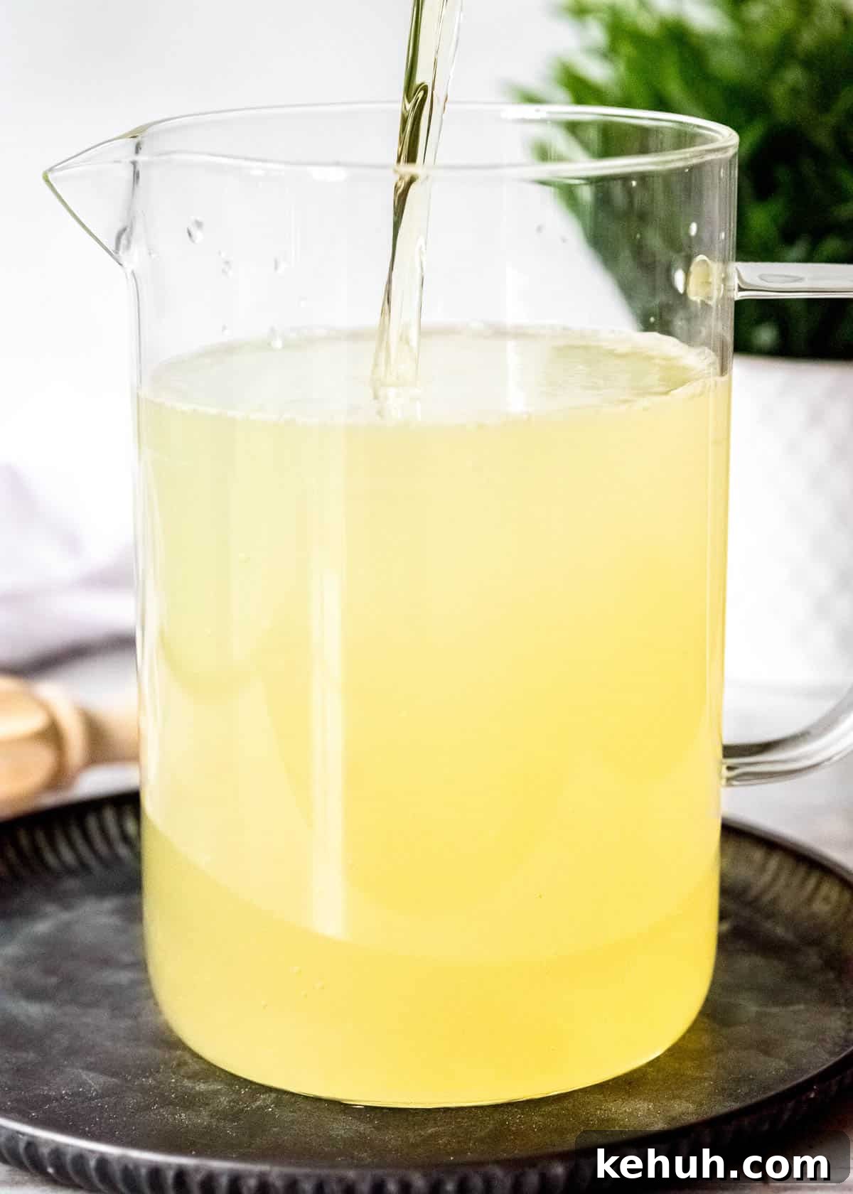 Peach Bourbon Lemonade Recipe — Refreshing Summer Cocktail 8 bourbon whiskey and peach schnapps pouring into a pitcher of homemade lemonade