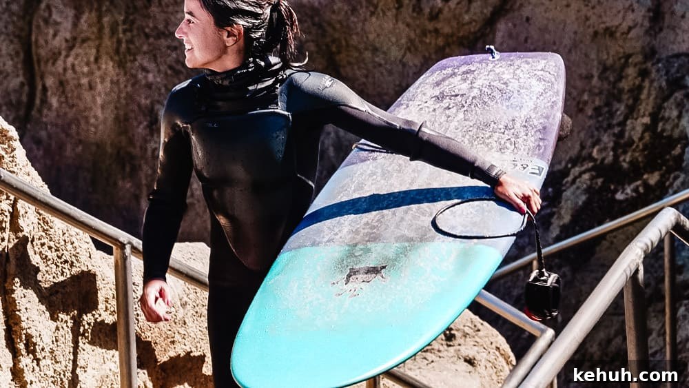 Chef Daniela Gerson carrying her board out of the water after surfing in Santa Cruz.