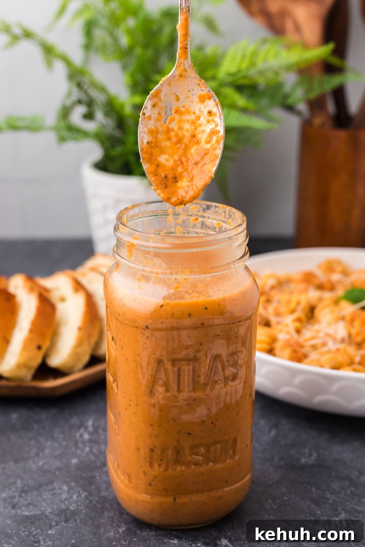 Creamy Vodka Sauce Recipe for Pasta 2 Spoon covered in Vodka Sauce being lifted out of a jar of Vodka Sauce