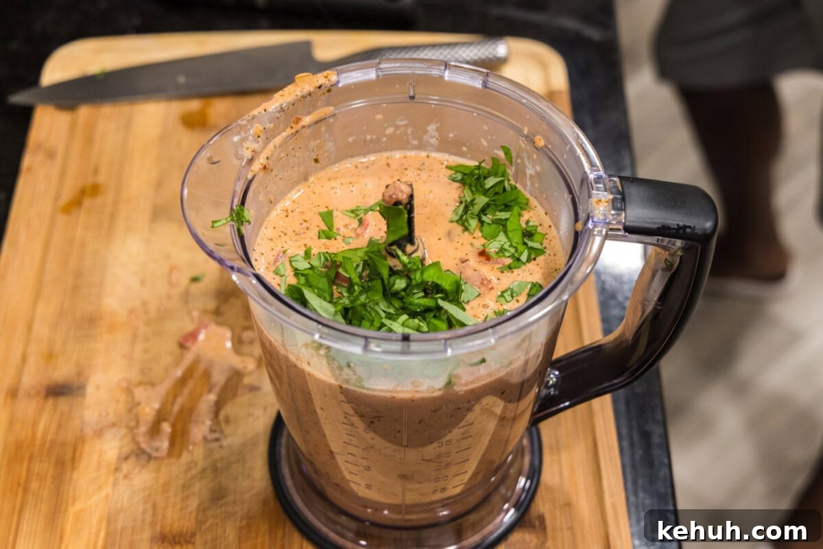 Creamy Vodka Sauce Recipe for Pasta 8 blitzing vodka sauce in a food processor with fresh basil leaves
