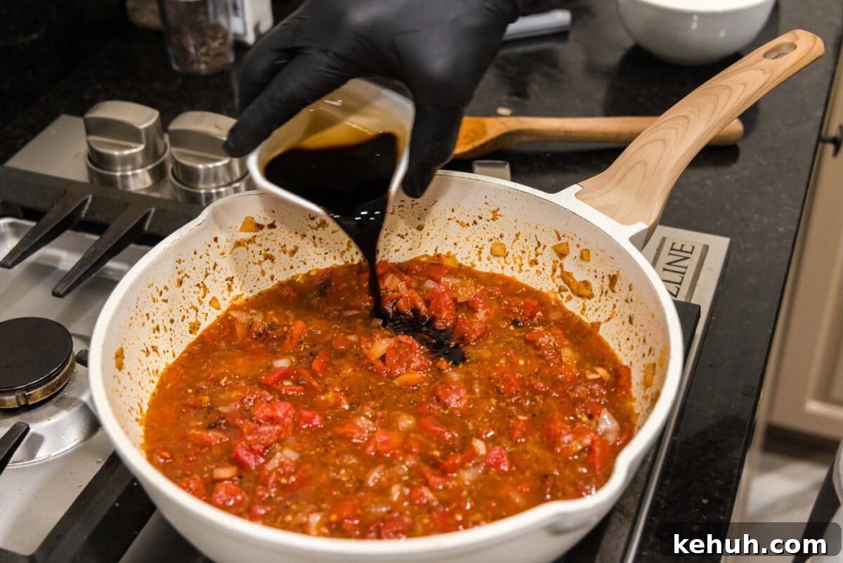 Creamy Vodka Sauce Recipe for Pasta 7 pouring balsamic vinegar into skillet with vodka sauce