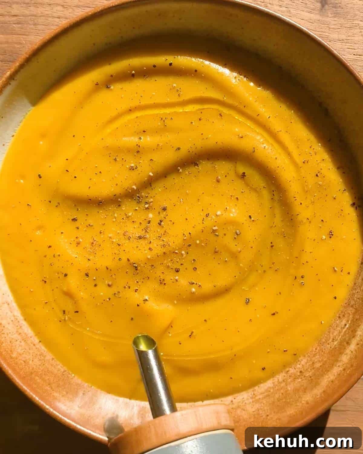 Creamy Roasted Butternut Squash Soup with Sage and Garlic 6 adding olive oil on a bowl of butternut squash soup